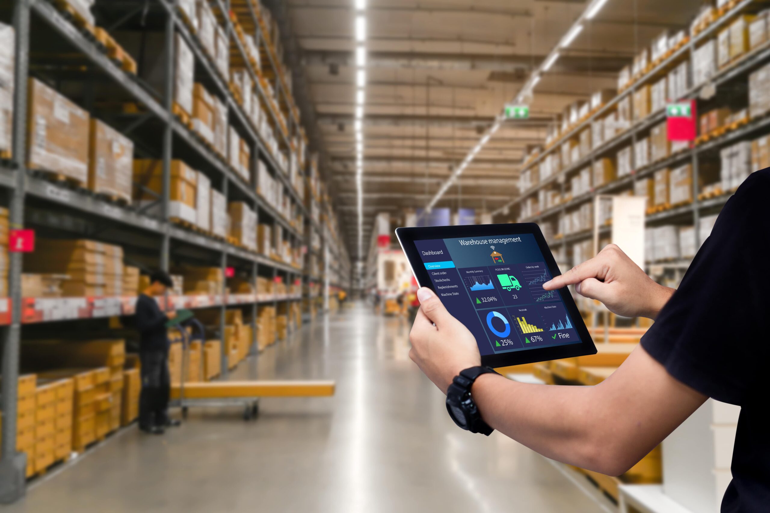 Man checks inventory in large warehouse using an ipad
